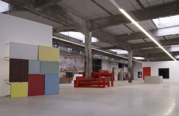 Vue générale de l'exposition + de réalité, école régionale des beaux-arts de Nantes, Hangar à Bananes, Nantes. Au premier plan à gauche : John M. Armleder, Sans titre, Furniture Sculpture, 2008. 8 tables en formica, tubes fluorescents. Collection Fonds cantonal d'art contemporain, Genève. Courtesy de l'artiste. Au centre : François Morellet, Beaming, 2002. Alucobon rouge. Courtesy de l'artiste. Photo Marc Dieulangard.