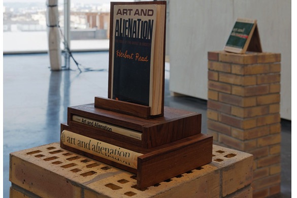 Vue de l'exposition Moucharabieh, Triangle France 13 février - 19 avril 2015 (détail). Au premier plan : Lina Viste Grønli, Art And Alienation (my collection), 2009, livres, mortier, briques, dimensions variables. Courtesy de l’artiste et galerie Gaudel de Stampa, Paris. Photo : Aurélien Mole.